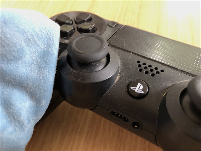 A cloth wiping a DualShock 4 Controller. 