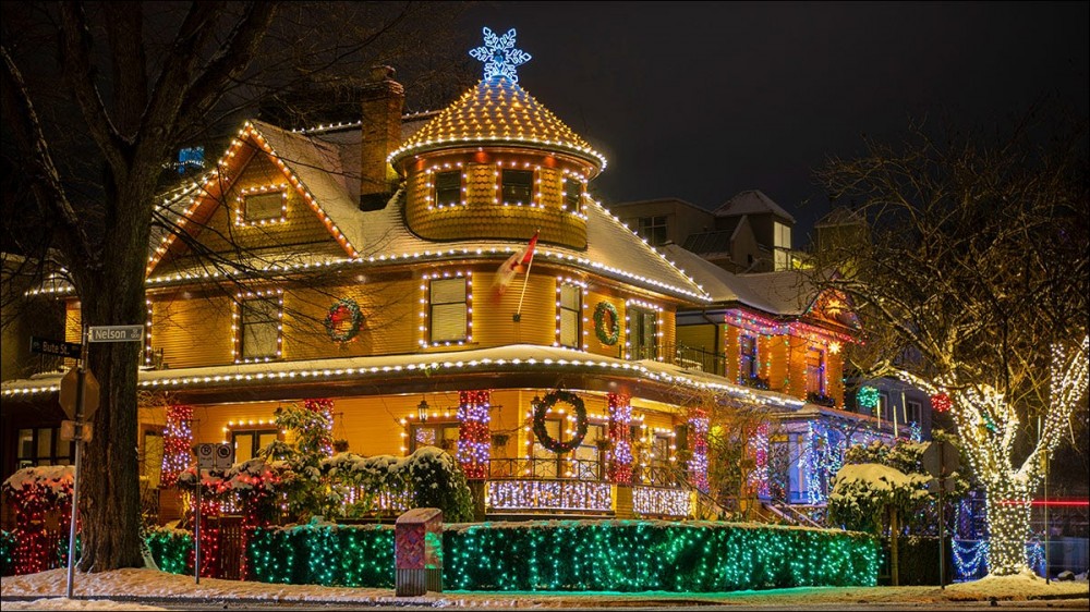 A traditional Victorian home, completely covered in Christmas lights.